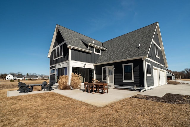 back of house featuring a yard, a patio, board and batten siding, and a shingled roof