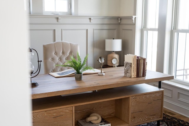 room details featuring a decorative wall and a wainscoted wall