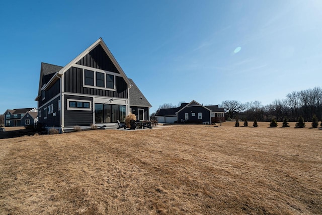 back of house with a yard, board and batten siding, and entry steps