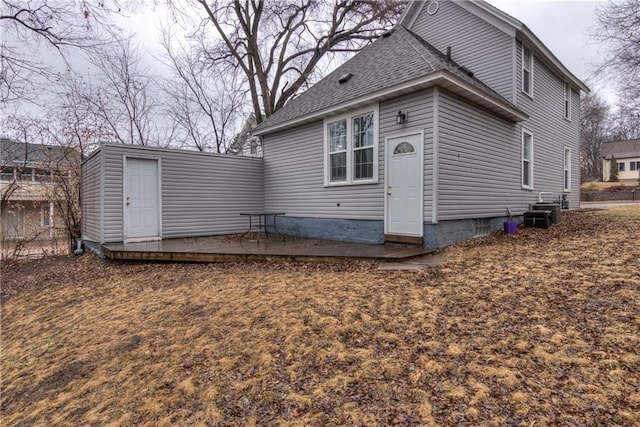 back of house with a shingled roof and a patio area