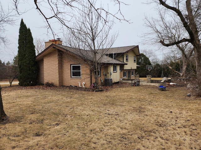 view of side of property with a chimney and central air condition unit