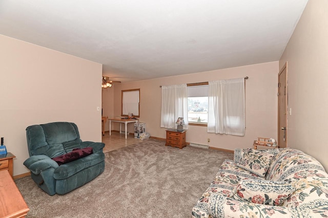 carpeted living area featuring a baseboard heating unit, a ceiling fan, and baseboards