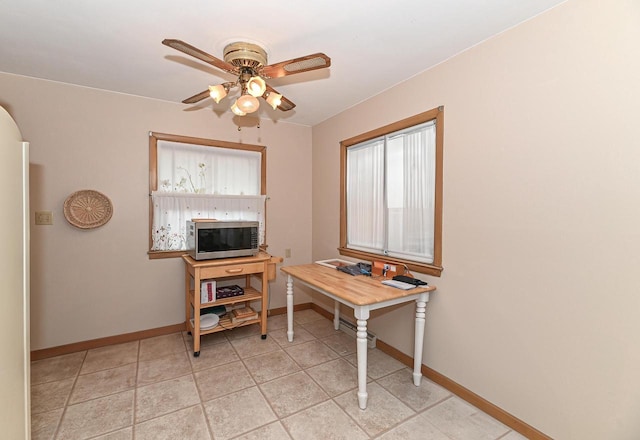 office area with baseboards, a ceiling fan, and light tile patterned flooring