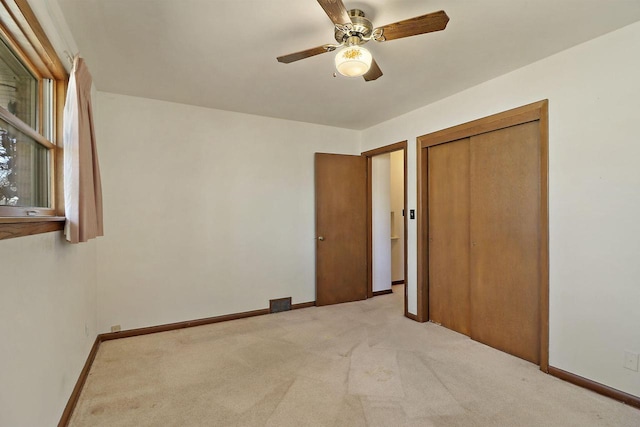 unfurnished bedroom with ceiling fan, visible vents, baseboards, a closet, and carpet