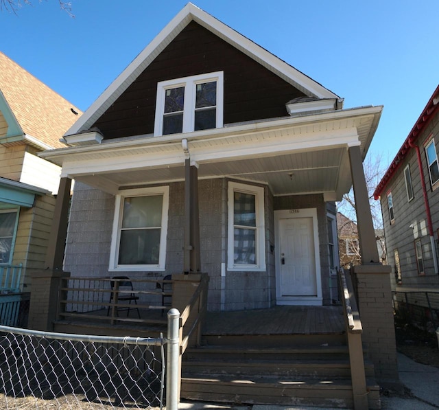 view of front facade featuring covered porch and fence