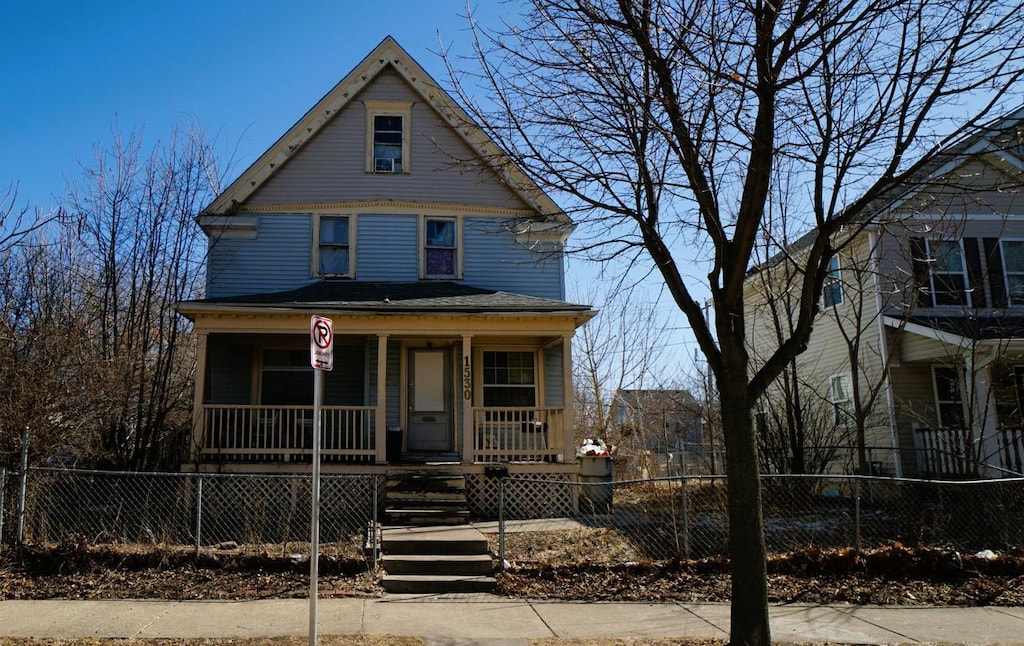 victorian home featuring a fenced front yard and a porch