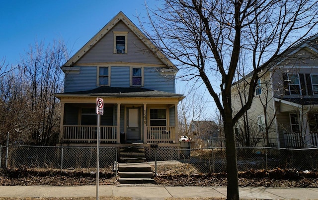 victorian home featuring a fenced front yard and a porch