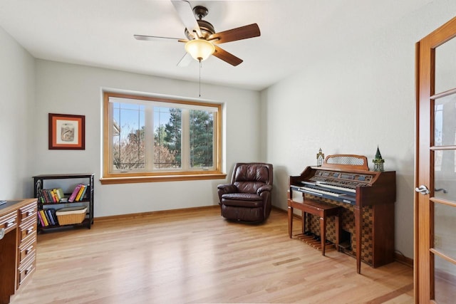 sitting room featuring baseboards, light wood-type flooring, and ceiling fan