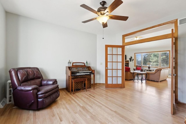 sitting room with light wood finished floors, ceiling fan, french doors, and baseboards