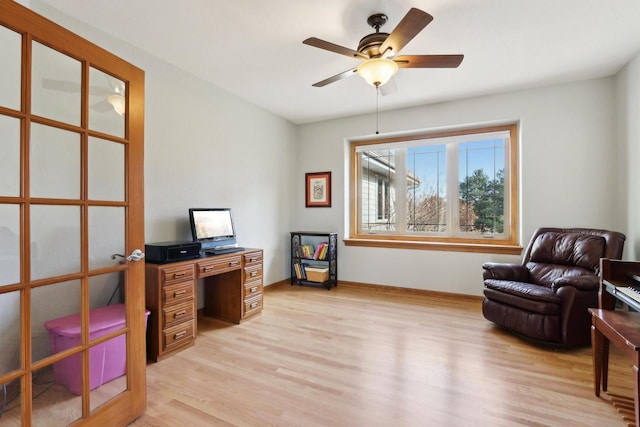 home office featuring light wood-style flooring, baseboards, and ceiling fan