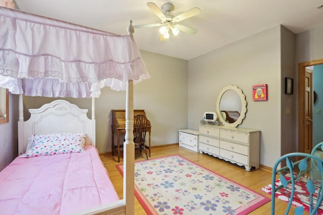 bedroom with baseboards, wood finished floors, and a ceiling fan