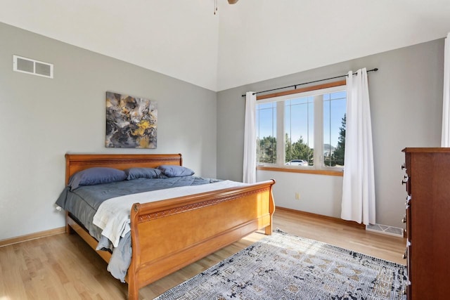 bedroom featuring light wood finished floors, visible vents, and baseboards