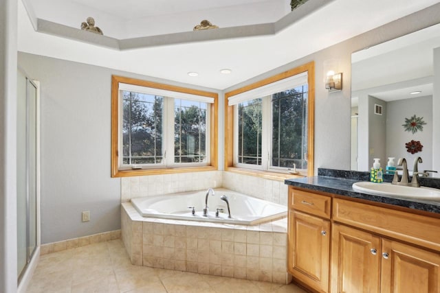 bathroom featuring tile patterned floors, plenty of natural light, a garden tub, and vanity