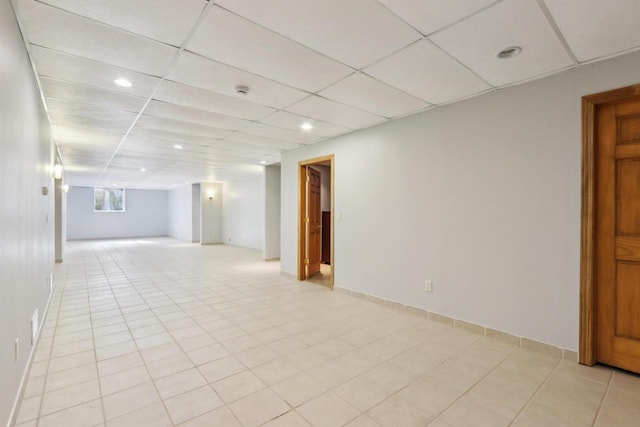 below grade area featuring light tile patterned flooring, recessed lighting, and a drop ceiling