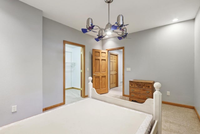 bedroom featuring connected bathroom, baseboards, and light colored carpet