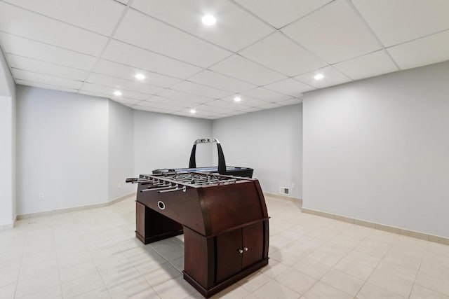 recreation room featuring a drop ceiling, visible vents, and baseboards