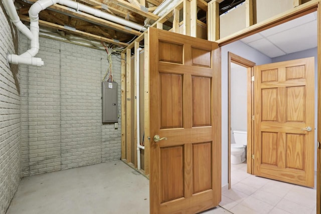 unfinished basement with electric panel and brick wall