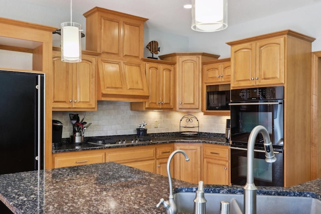 kitchen with decorative backsplash, black appliances, dark stone counters, and a sink