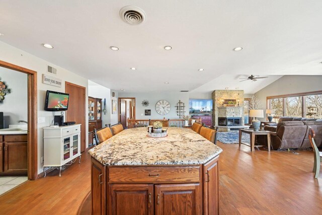 kitchen featuring a fireplace, visible vents, and light wood-type flooring