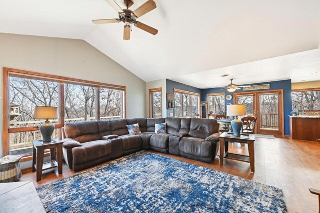 living area with ceiling fan, lofted ceiling, and wood finished floors