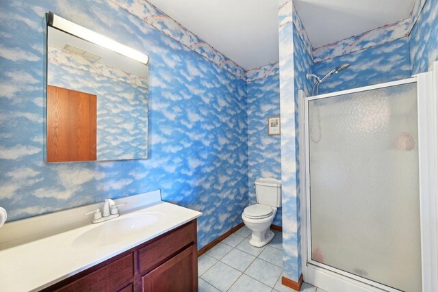 bathroom featuring tile patterned floors, toilet, a stall shower, and wallpapered walls