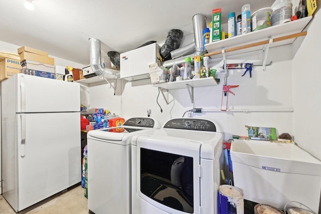 washroom with washer and clothes dryer, laundry area, and a sink