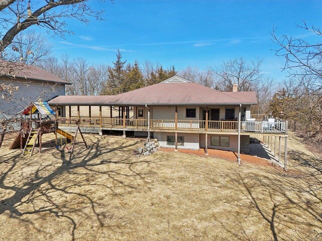 rear view of property with a wooden deck and a chimney