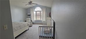 bedroom featuring lofted ceiling and light carpet