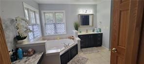 full bathroom with a bath, vanity, and tile patterned flooring