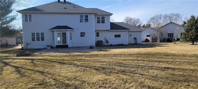 rear view of property with a patio area, a lawn, and central AC