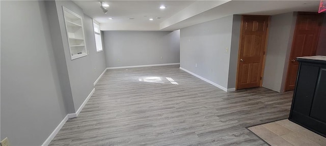 empty room featuring recessed lighting, baseboards, and light wood-style floors