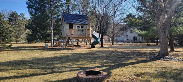 view of yard with a fire pit, a deck, and fence