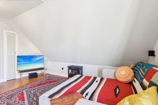 bedroom with vaulted ceiling and wood finished floors