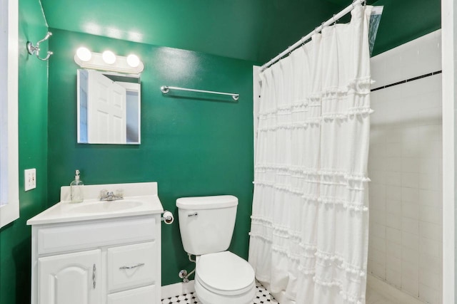 full bathroom with vanity, toilet, and tiled shower