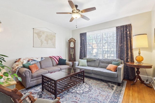 living room with baseboards, wood finished floors, and a ceiling fan