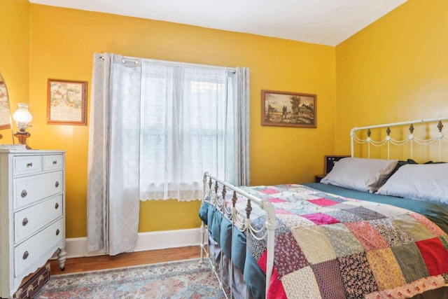 bedroom with wood finished floors and baseboards