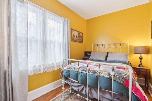 bedroom with wood finished floors and baseboards