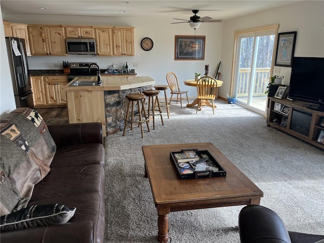 living room featuring carpet flooring, baseboards, and ceiling fan