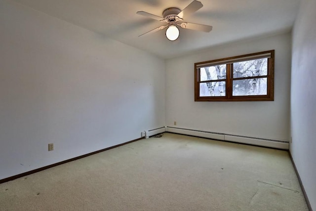 spare room with carpet floors, a baseboard radiator, a ceiling fan, and baseboards