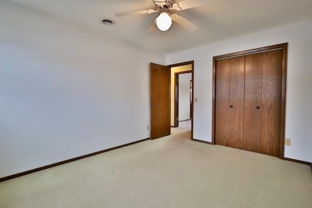 unfurnished bedroom with a ceiling fan, a closet, light carpet, and baseboards