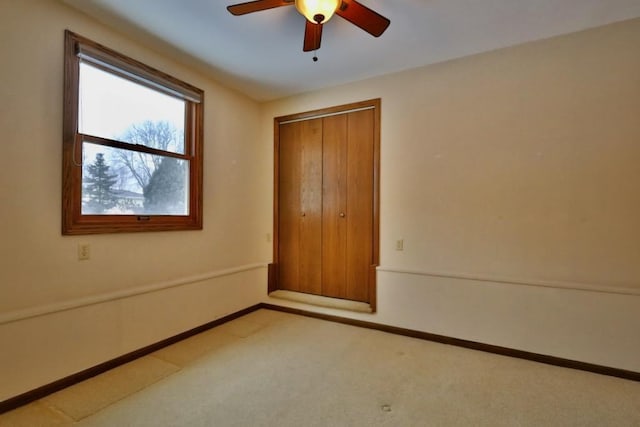 empty room featuring carpet floors, ceiling fan, and baseboards