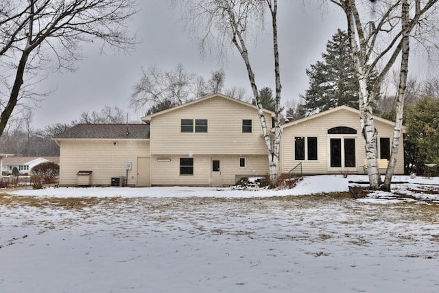 snow covered property with central air condition unit