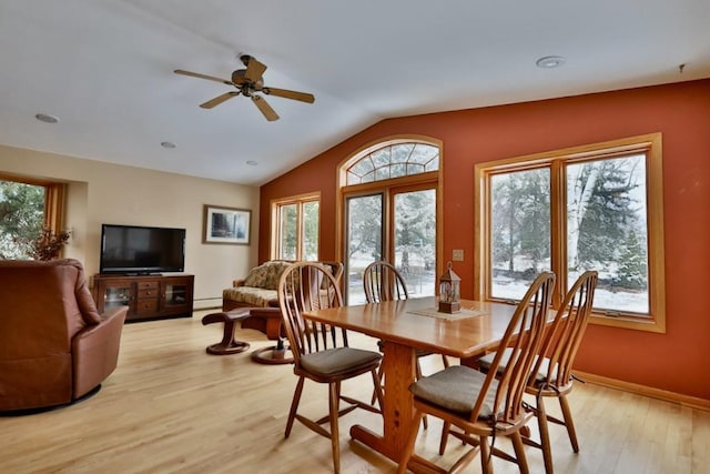 dining space featuring light wood-style floors, vaulted ceiling, baseboard heating, and a wealth of natural light