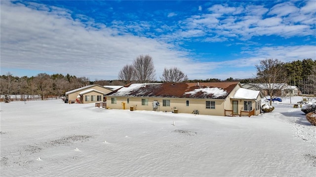 view of snow covered back of property