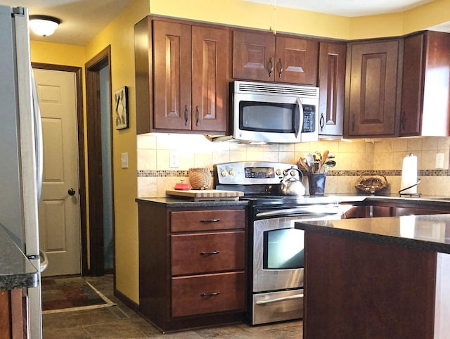 kitchen with a sink, baseboards, stainless steel appliances, and backsplash