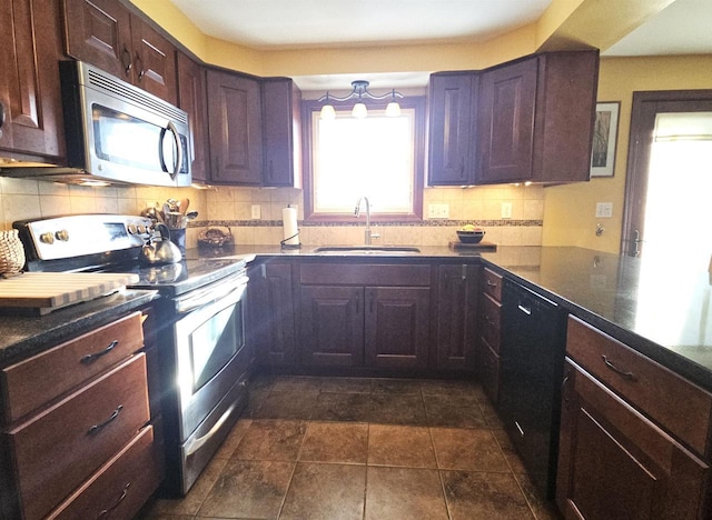 kitchen featuring a sink, dark brown cabinets, appliances with stainless steel finishes, backsplash, and dark countertops