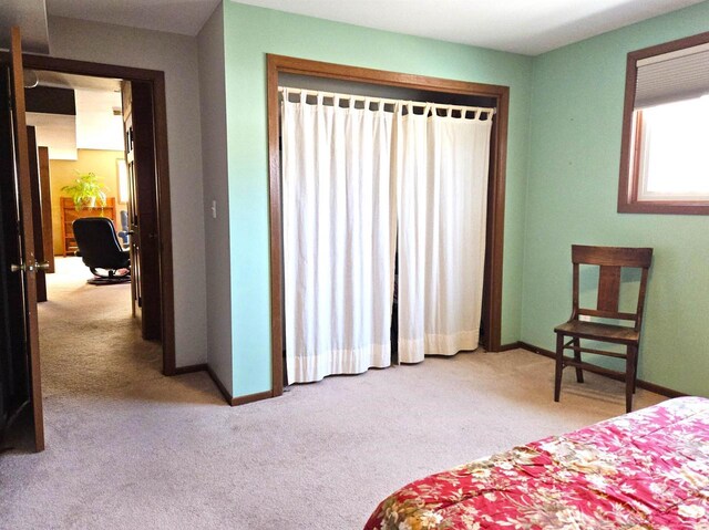 bedroom featuring light carpet and baseboards