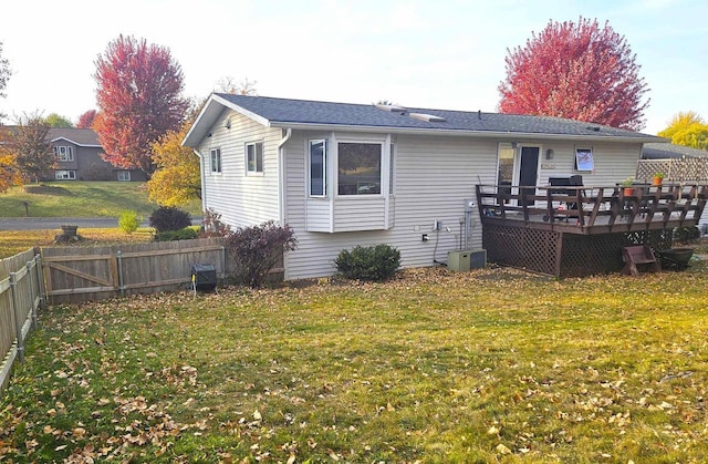 back of property featuring fence private yard, a lawn, and a deck