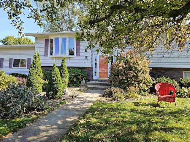 view of front facade with a front lawn and brick siding