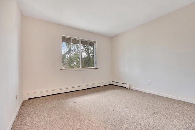 carpeted spare room with a baseboard radiator and baseboards